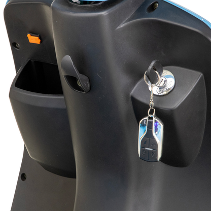 Close-up of the Bespoke Elite Recreational 3-Wheel Scooter’s black dashboard featuring a digital speedometer, key with remote fob in the ignition, open storage compartment, and convenient bag hook.