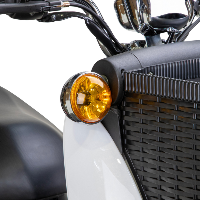 Close-up of the Bespoke Supreme Euro-Style Recreational 3-Wheel Scooter’s amber turn signal, mounted by a black woven-style front grille and white body panel. The handlebar and mirror highlight its electric brake assist technology.