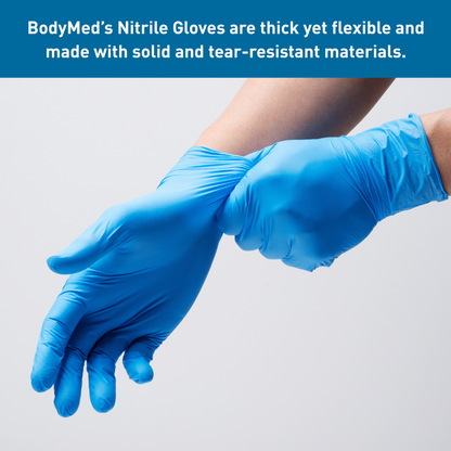 A person wearing BodyMed Nitrile Exam Gloves, pulling one onto their left hand. Text above highlights the gloves as thick, flexible, and tear-resistant—built with specifications ideal for demanding tasks.