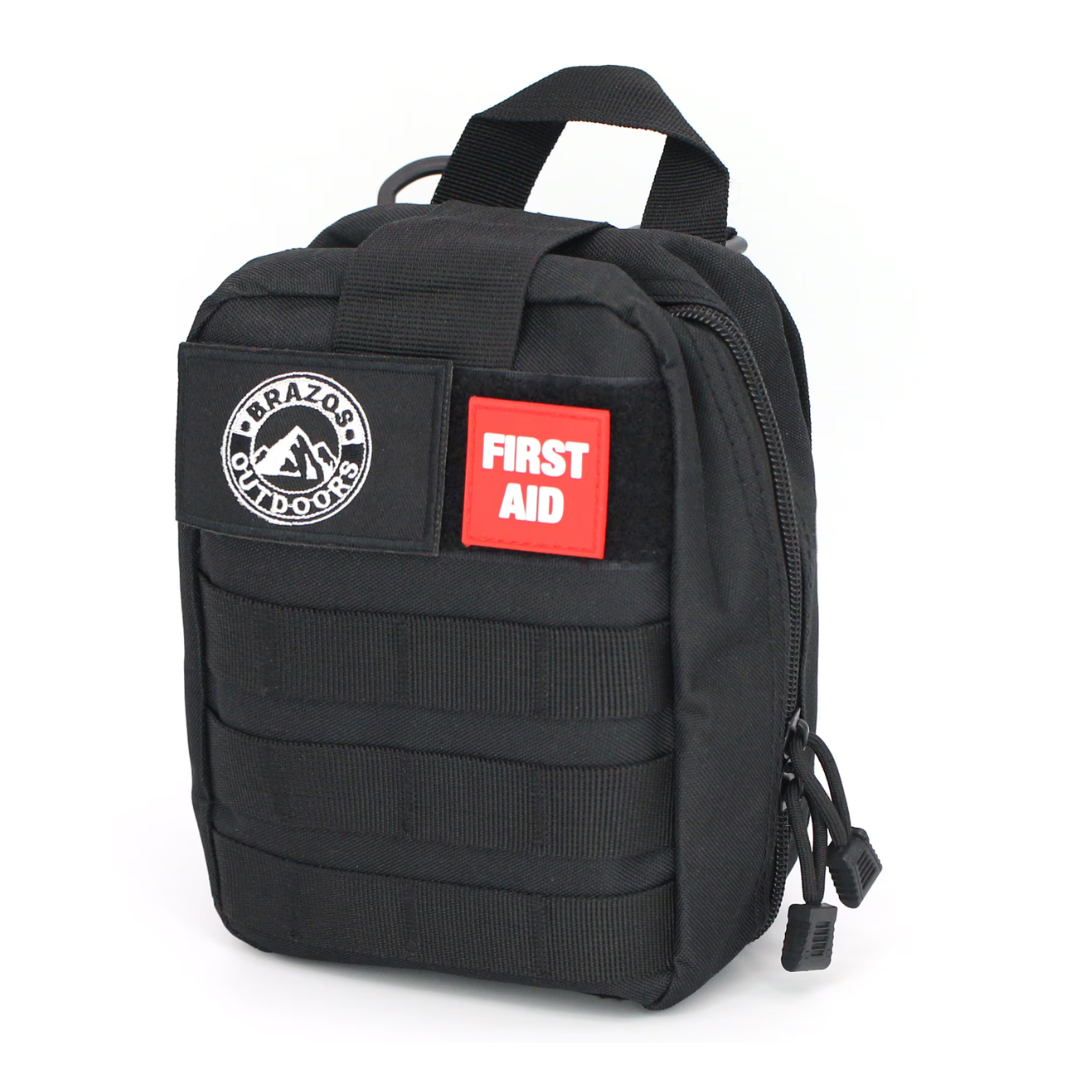 The Brazos First Aid Survival Kit - 250 Pieces is a compact black pouch with a handle, FIRST AID and Brazos Outdoors patches, zippered compartments, and MOLLE webbing on the front.