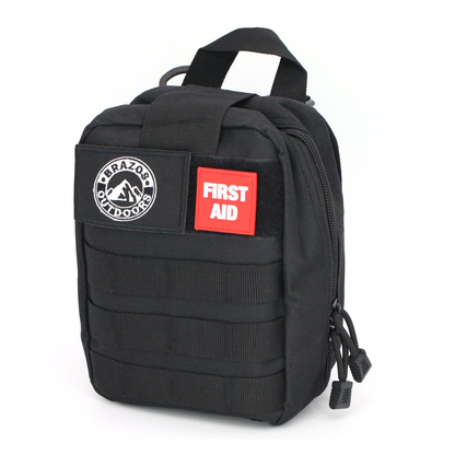 The Brazos First Aid Survival Kit - 250 Pieces is a compact black pouch with a handle, FIRST AID and Brazos Outdoors patches, zippered compartments, and MOLLE webbing on the front.