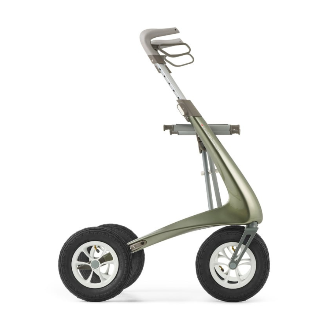 The ByACRE Carbon Overland All-Terrain Rollator is a modern, minimalist trolley with two large black wheels fitted with pneumatic tires and a sleek carbon fiber frame. It has an ergonomically designed handle and compartments for bags and accessories, set against a plain white background.