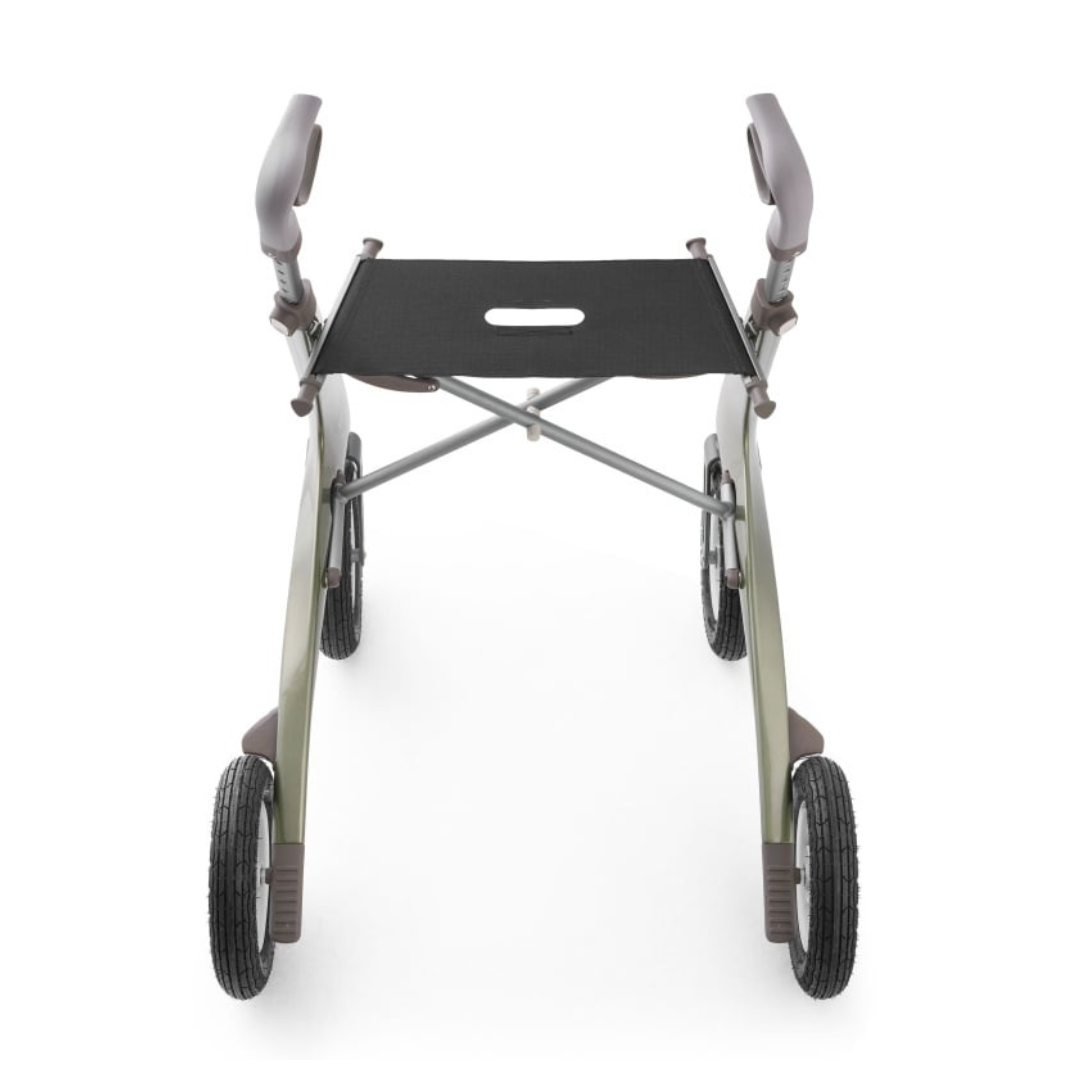The ByACRE Carbon Overland All-Terrain Rollator features a lightweight, foldable carbon fiber frame with four wheels and a sleek, curved design. It has padded handles and a black seat with a grip cutout, viewed from the front.