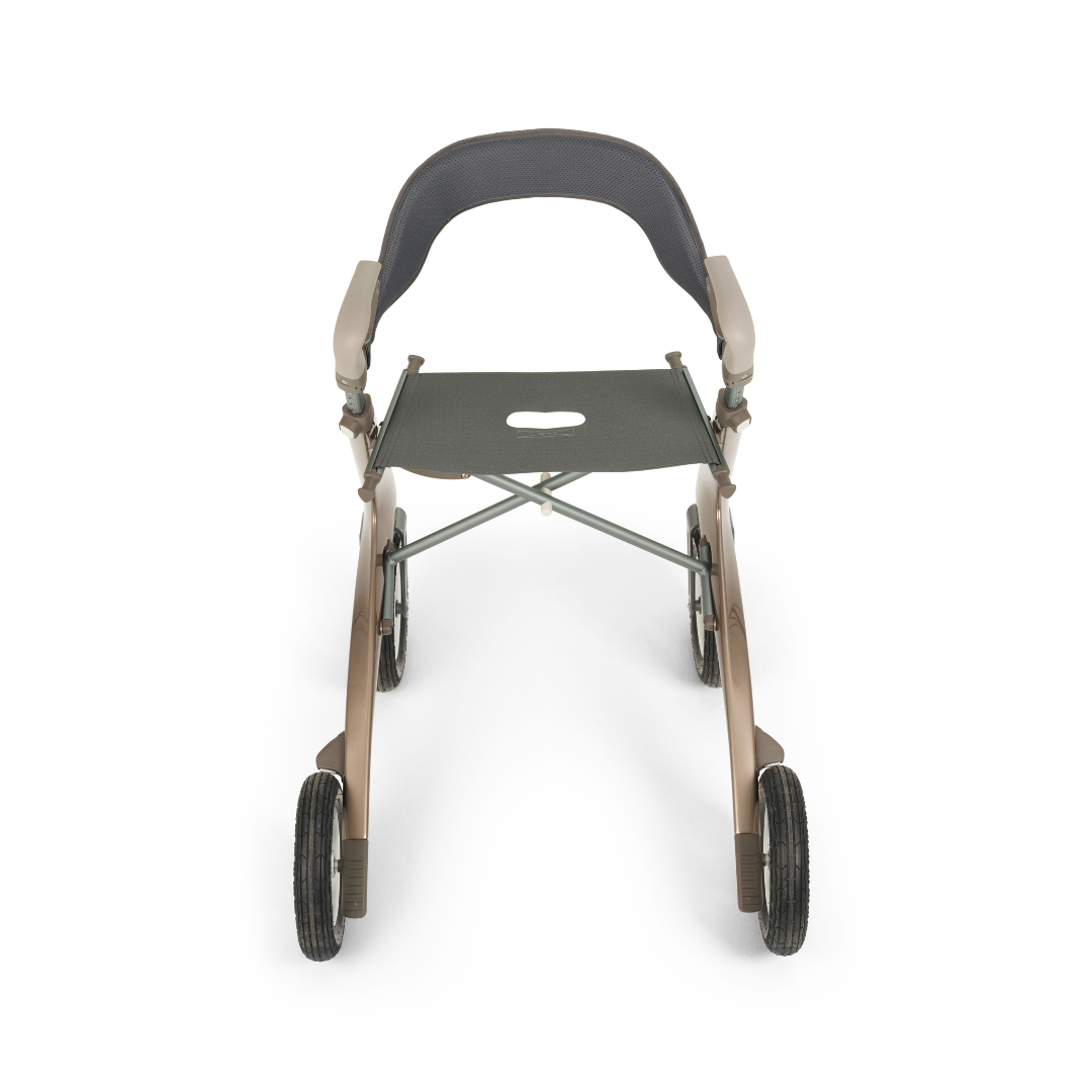 A front view of the Backrest For byAcre Overland Carbon Fiber Rollators shows a modern, lightweight rollator with four wheels, armrests, a supportive backrest, and a seat with a center cutout on a sleek black and beige metallic frame.