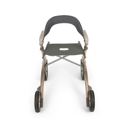 A front view of the Backrest For byAcre Overland Carbon Fiber Rollators shows a modern, lightweight rollator with four wheels, armrests, a supportive backrest, and a seat with a center cutout on a sleek black and beige metallic frame.
