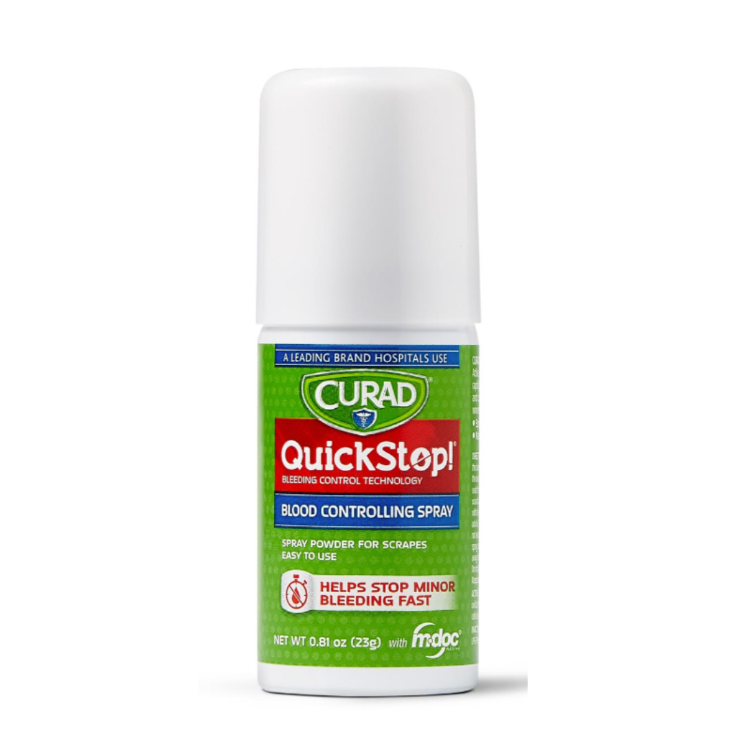 A white spray bottle of CURAD QuickStop! Blood Controlling Spray with a green and red label, designed for fast bleeding control of minor scrapes. The label features first-aid convenience, hospital use, and easy application.