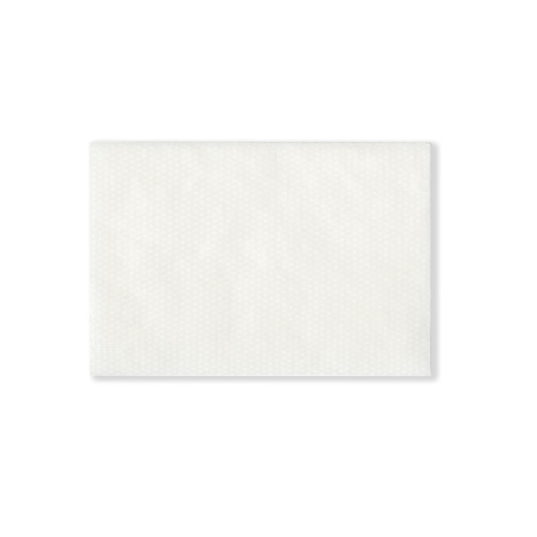 A rectangular white sheet with a subtle dotted texture, resembling Medline CURAD Sterile Nonadherent Dressing Pads, is placed on a plain white background.