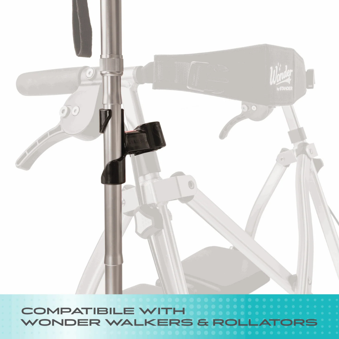 Close-up of the Cane Holder For Stander Walkers & Rollators attached to a walker, with "Compatible with Walkers & Rollators" text at the bottom. The grayscale walker appears in the background.