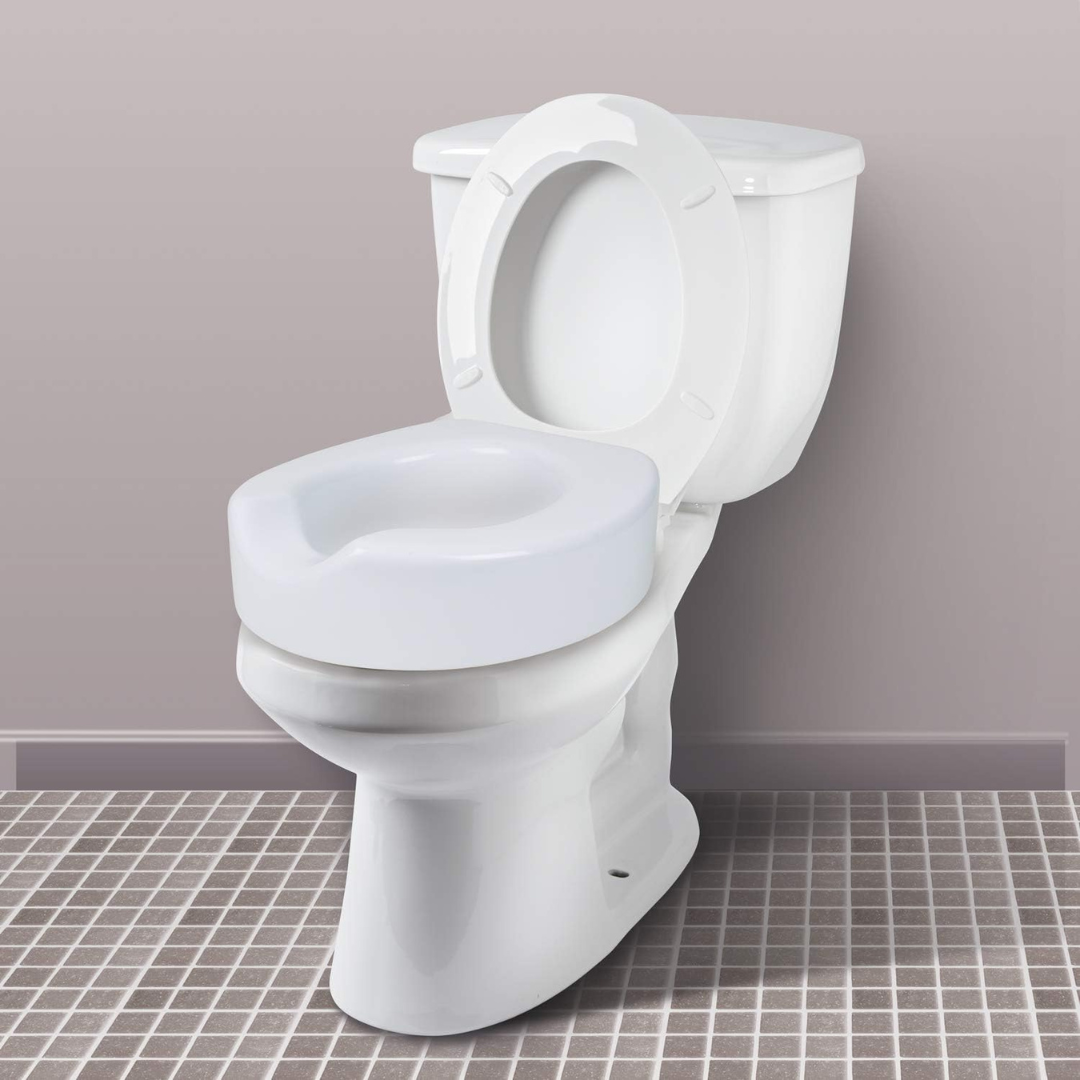 The Carex Bathroom Safety Rail, a universal standing aid that fits over the toilet, is installed with sturdy handles for support atop a tiled bathroom floor against a light-colored wall.