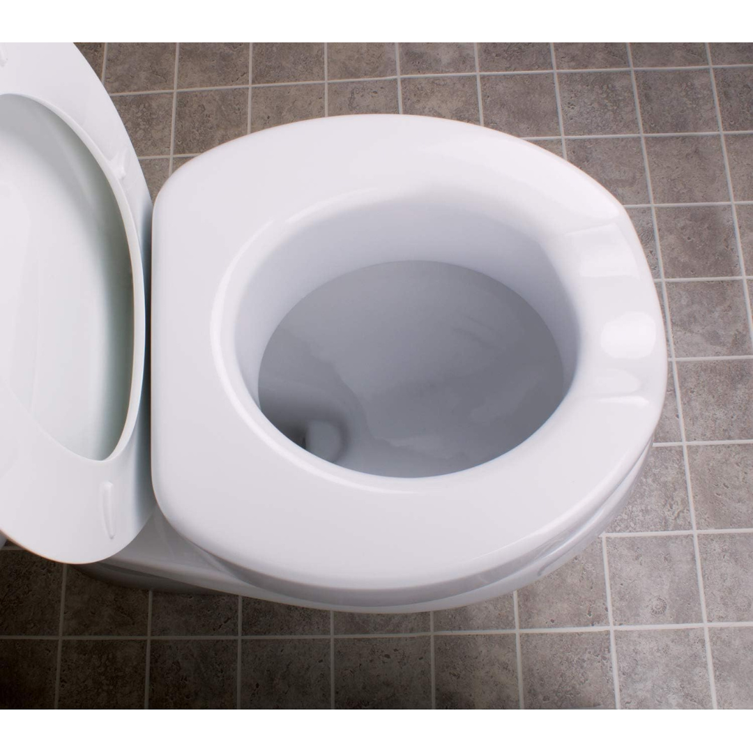 The Carex 4" Toilet Seat Riser With Quick-Lock, shown with the lid up on a white toilet, is pictured from above on a gray tiled floor.