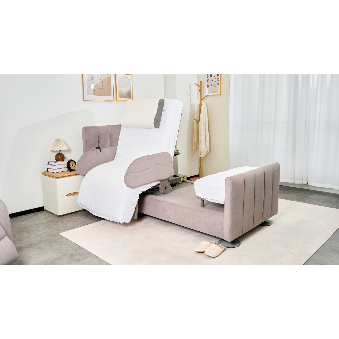 A modern living room features the Charme Starsleep Orin Rotating Full Electric Lift Assist Bed with Heat & Massage extended, topped with a white blanket. Nearby are slippers, a nightstand with lamp and books, wall art, and light streaming through sheer curtains.