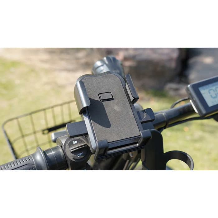 A close-up shows a black phone holder on the handlebars of a Green Transporter Cheeta Ninja All-Terrain HD Scooter Golf Cart, with part of its LCD display and control switches visible. The background features blurred grass and rocks outdoors.