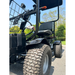 Close-up of a black Green Transporter Cheeta Ninja All-Terrain HD Scooter Golf Cart with large rugged tires on pavement. A front basket is visible, with green trees and a clear blue sky in the background.
