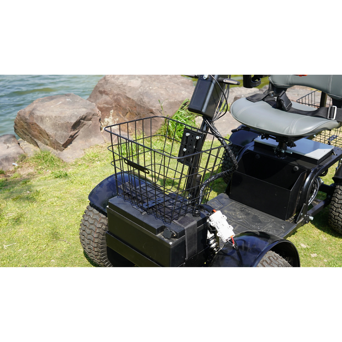A close-up of the Green Transporter Cheeta Ninja All-Terrain HD Scooter Golf Cart parked on grass by rocks and water, highlighting its front basket, seat, large wheels, and off-road capabilities.