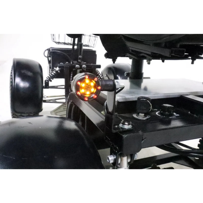 Close-up of the Green Transporter Cheeta Ninja All-Terrain HD Scooter Golf Cart’s rear, showing its illuminated orange circular tail light, sturdy frame detail, and large black wheels designed for all-terrain use.