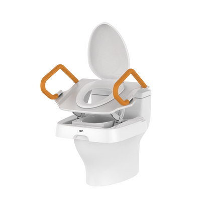 A white toilet with an elevated seat attachment and orange support handles, designed for accessibility and support, is shown with the lid open. The Comfort Steady Powered Toilet Seat Lifter | VOCIC AX12 provides powered lifting assistance and added stability, making it ideal for those seeking safe and comfortable bathroom use.