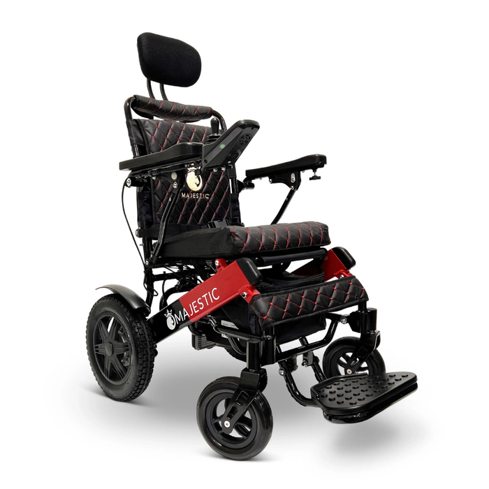 The ComfyGo MAJESTIC IQ-9000 is a modern electric wheelchair with black and red quilted padding, headrest, armrests, footrest, large rear wheels, a digital joystick controller, and remote control on a red frame with MAJESTIC branding.