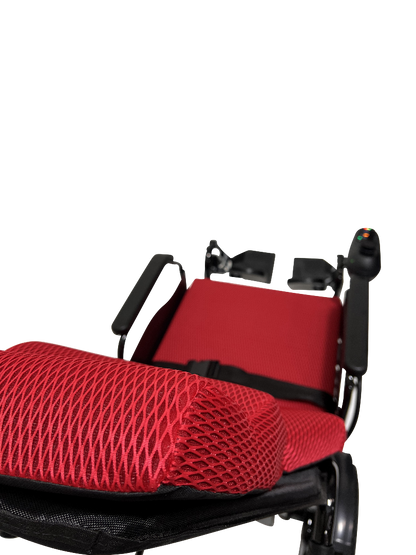 The ComfyGo X-9 Remote Controlled Powerchair, featuring an automatic reclining seat in red and black with breathable mesh fabric, is shown up close against a black background. The innovative mobility solution includes a visible control joystick on the armrest.