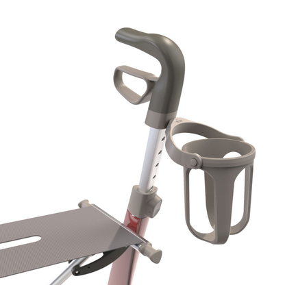 Close-up of a Cup Holder For ByAcre Rollators attached to the handle, with part of the seat visible. Designed for convenience, it features an adjustable fit. The colors shown are mainly grey and red.
