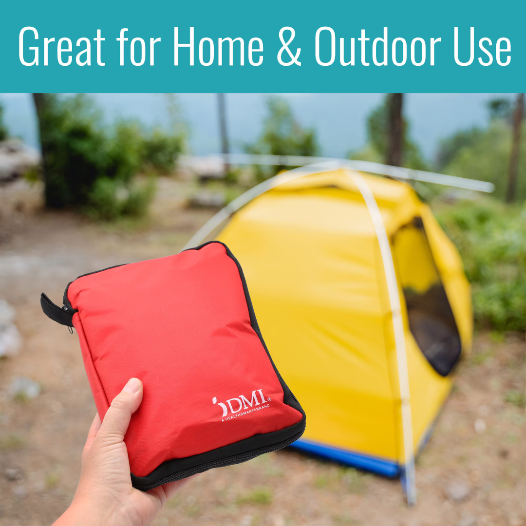 A hand holds the DMI 298-Piece Complete Emergency First Aid Kit outdoors, with a yellow tent and greenery in the background. Text above reads, “Great for Home & Outdoor Use.”.