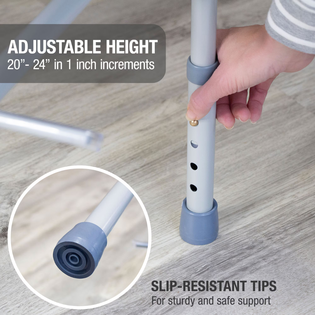 A hand adjusts the height of a metal leg with three holes and a push-button on the DMI Drop Arm Portable Bariatric Toilet Commode w/ Extra-Wide Seat. The leg has a gray slip-resistant tip. Adjustable Height: 20-24 in (1 in increments). Slip-Resistant Tips.