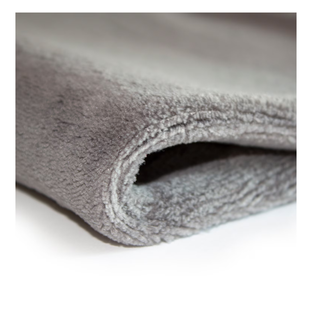 A close-up of a folded, soft grey fleece blanket shows plush, thick fabric—ideal to pair with your DMI Dry and Moist Heat Electric Heating Pad for extra comfort and pain relief.