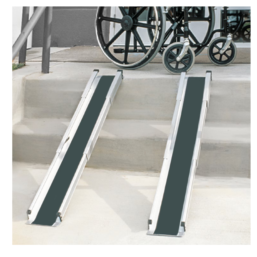 Two DMI® Retractable Lightweight Portable Wheelchair Ramps with non-skid surfaces are positioned on concrete steps beside a handrail, ensuring secure and easy wheelchair access to the upper level.