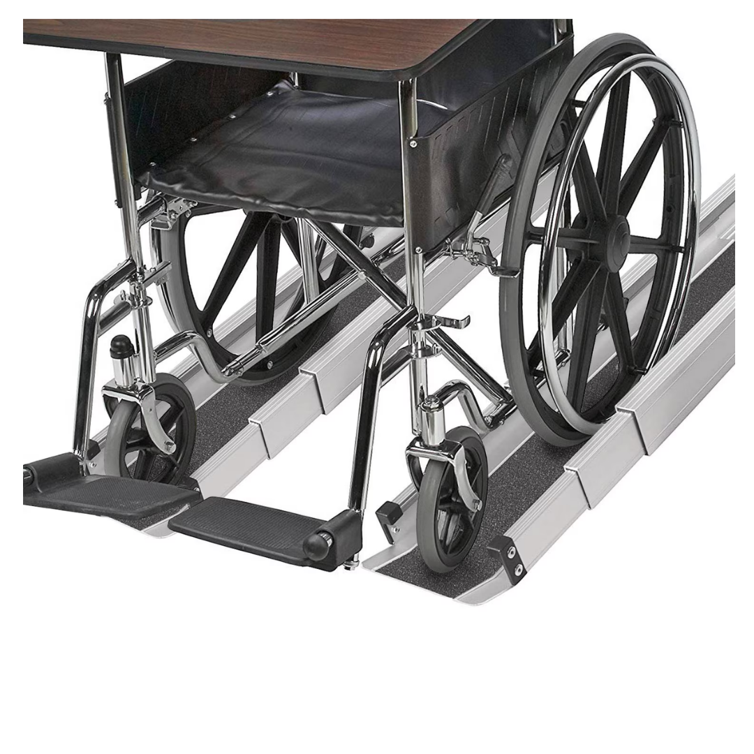 A wheelchair sits on the DMI® Retractable Lightweight Portable Wheelchair Ramps with a tabletop attached, demonstrating accessibility. The ramp’s non-skid grooves ensure the wheelchair wheels are securely aligned.