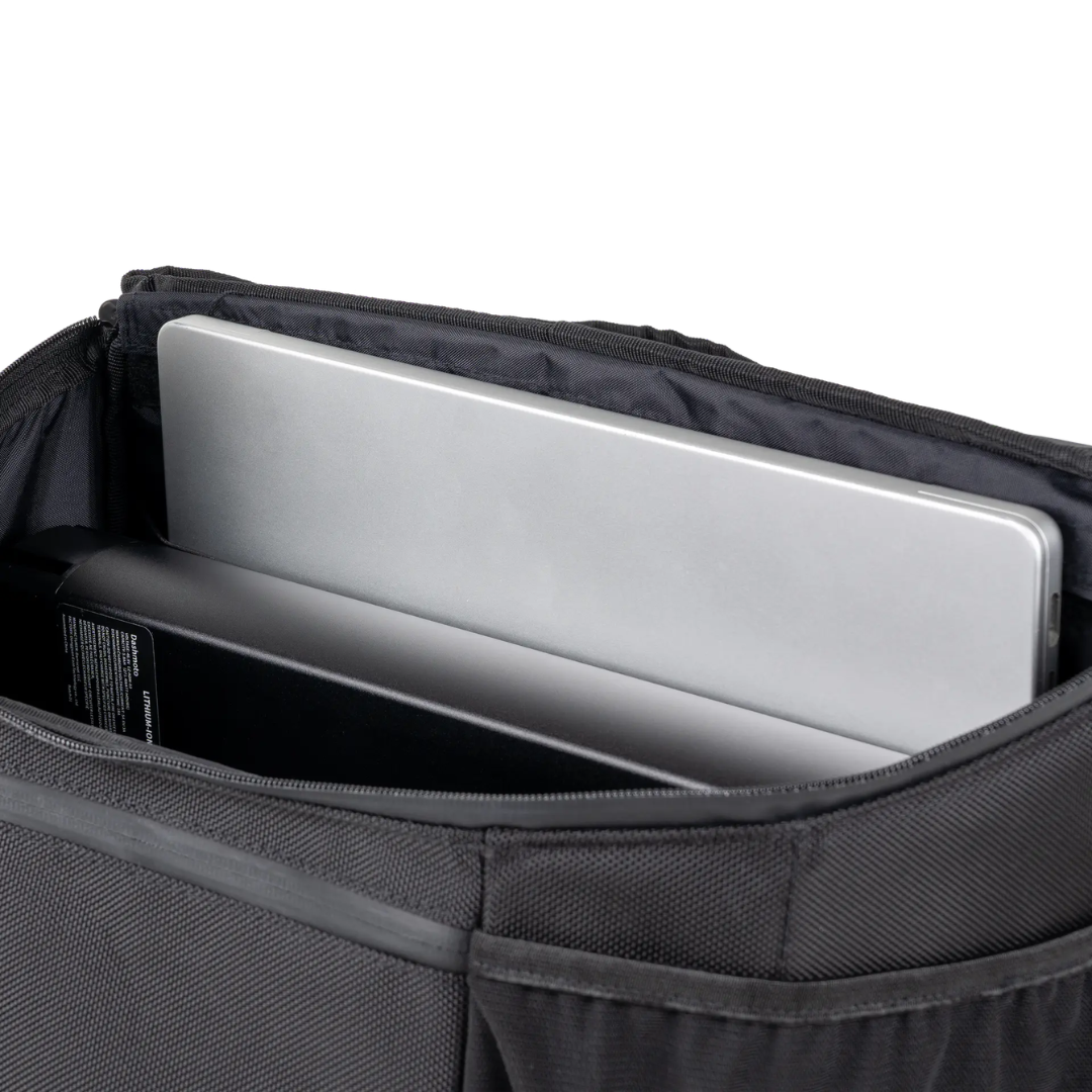 A silver laptop and a black rectangular object are shown inside the pocket of a black fabric backpack, making it an ideal companion to the Saddle Bag For Dashmoto Dash 3 Scooter or other essential mobility accessories.