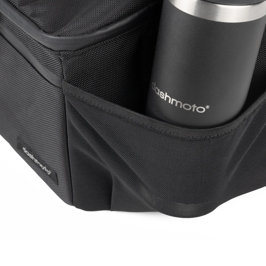 A close-up of the Saddle Bag For Dashmoto Dash 3 Scooter in black, featuring a mesh side pocket holding a black stainless steel tumbler labeled Dashmoto—perfect for carrying essential mobility accessories with your Dashmoto Dash 3 scooter.