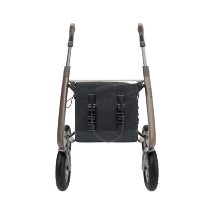 A modern, lightweight rollator walker with two large front wheels, ergonomic handles, and a Daypack For ByAcre Carbon Fiber Rollators backpack attached between the frame legs, seen from the front.