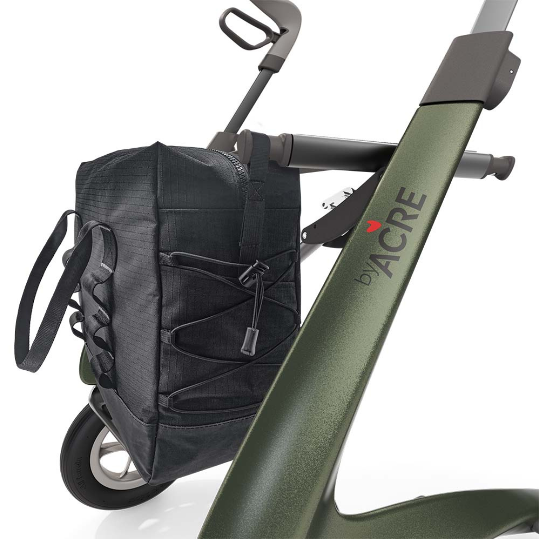 Close-up of a green ByAcre Carbon Fiber Rollator with the Daypack attached to its side. Features include sturdy handles, large wheels, a bungee cord securing the Daypack, and "by ACRE" text on the frame.