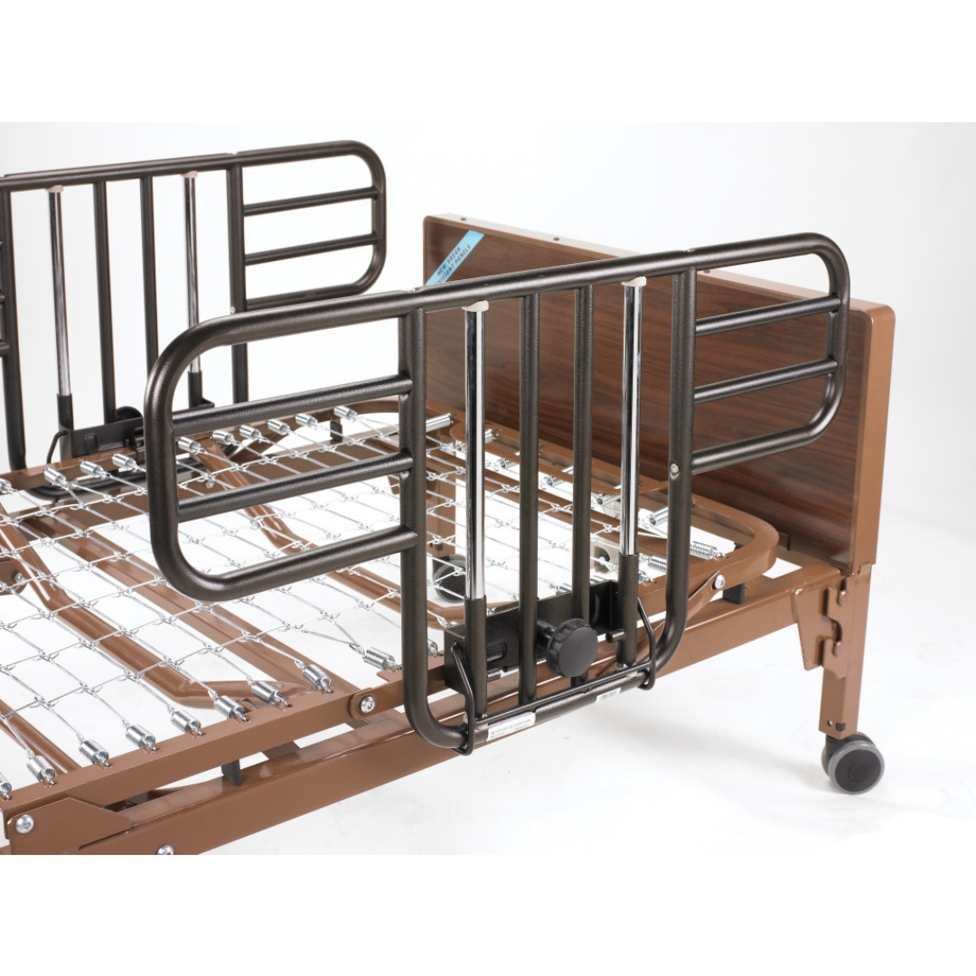A close-up of the Drive Delta® Ultra-Light 1000 Bariatric Full-Electric Low Bed with metal rails, brown frame, and wheeled legs, set against a plain white background.