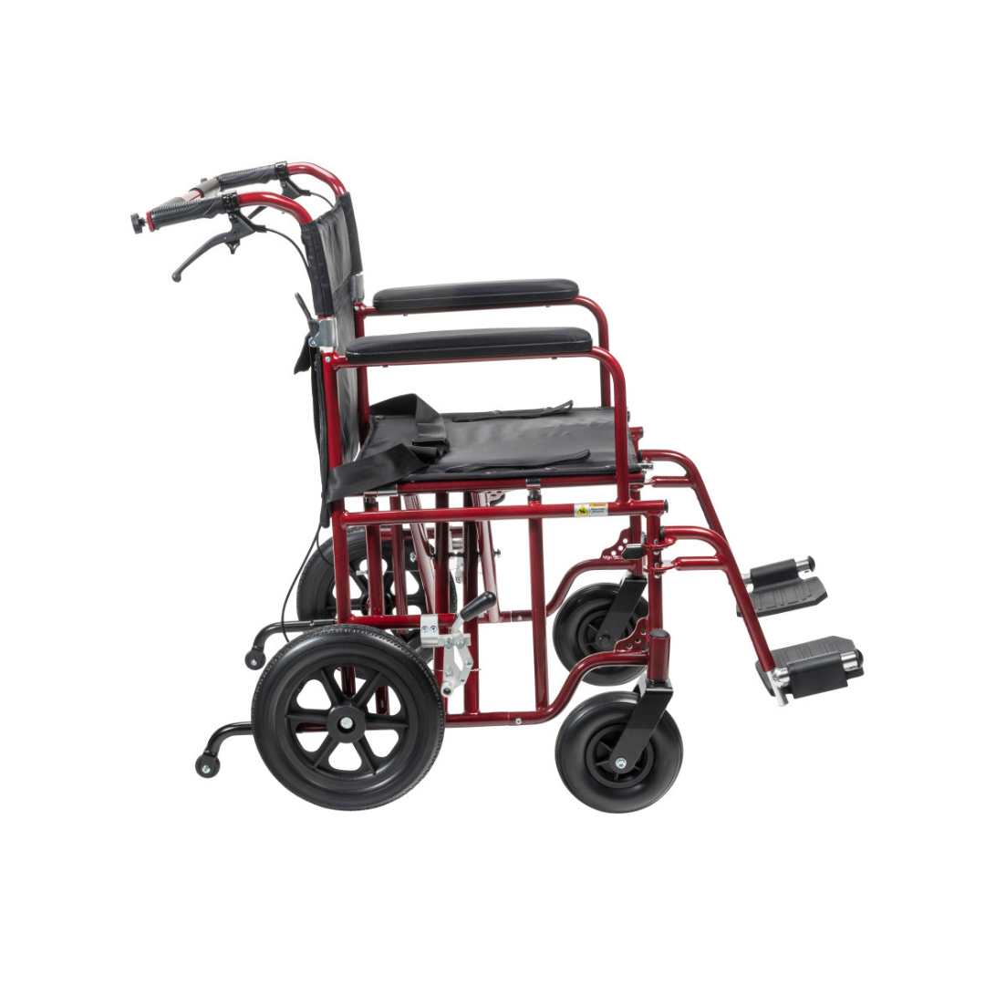 The Drive Bariatric Aluminum Transport Chair - 22" Seat is red with a black seat, armrests, and footrests. Shown from the side, it features flat-free rear and front wheels for easy mobility and reliable transport.