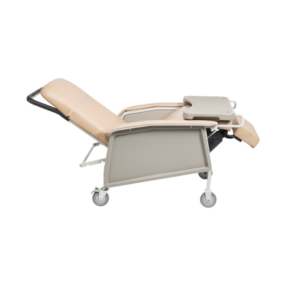 The Drive 3-Position Geri-Chair Recliner with Wheels is a beige medical chair featuring armrests and an attached tray table, shown in a side view against a white background.