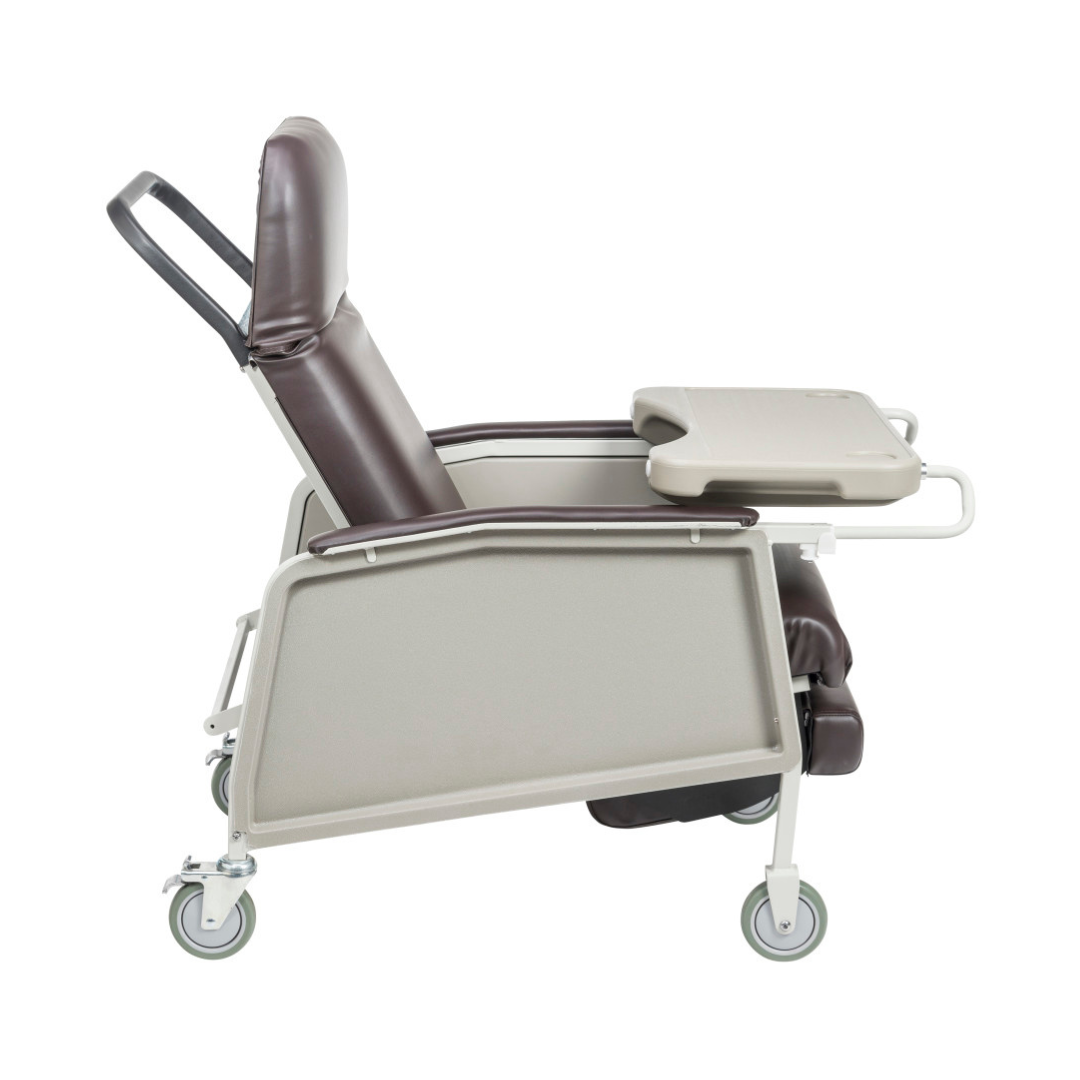 A side view of the Drive 3-Position Geri-Chair Recliner with Wheels, featuring brown cushions, a grey frame, wheels, and a beige tray on the right armrest—designed for comfortable patient care.
