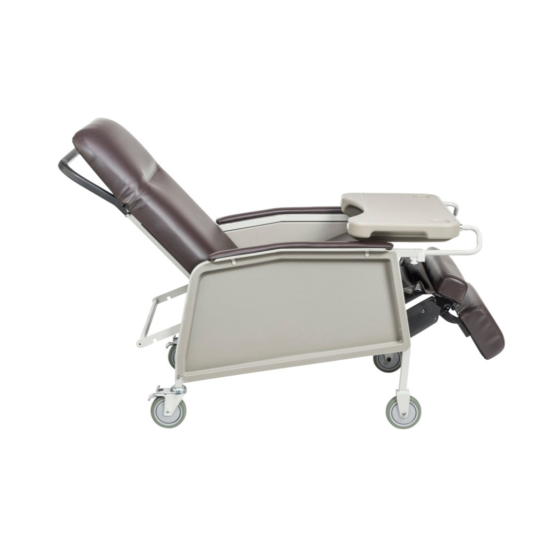 The Drive 3-Position Geri-Chair Recliner with Wheels is shown from the side, featuring a brown and beige design, an attached tray table, and an adjustable leg rest.