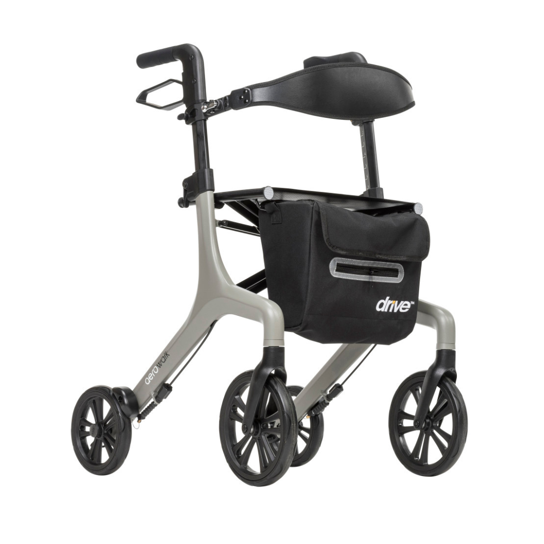 The Drive AeroWalk Ultra-Lite Rollator is a lightweight silver walker with four large black wheels, ergonomic adjustable handles, padded seat, and a front black storage bag labeled “drive” for easy mobility support.