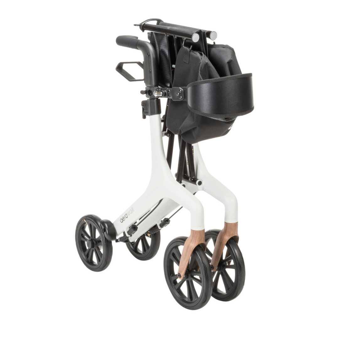 The Drive AeroWalk Ultra-Lite Rollator features a modern white and wood-accented frame, four large black wheels, black adjustable handles, and a front black storage bag for convenient mobility support.