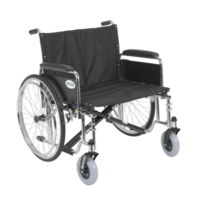 The Drive Bariatric Sentra EC Heavy-Duty Extra-Wide Wheelchair features a wide black frame, large rear wheels, small front wheels, padded armrests, metal construction, and supports up to 700 lbs for heavy-duty use.