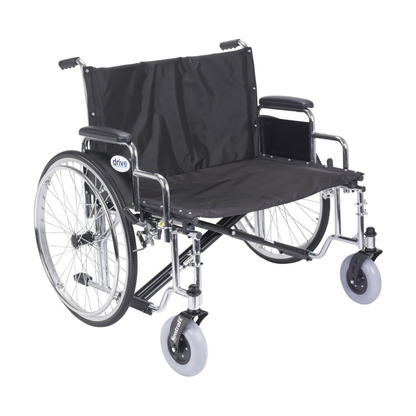 The Drive Bariatric Sentra EC Heavy-Duty Extra-Wide Wheelchair is a wide black wheelchair with large rear wheels, hand rims, padded armrests, and footrests. It is empty and shown against a white background.