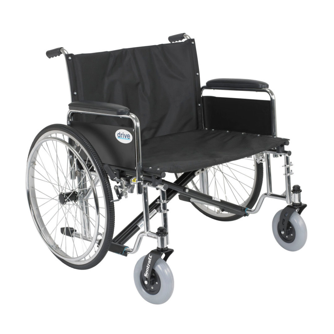 The Drive Bariatric Sentra EC Heavy-Duty Extra-Wide Wheelchair features a black metallic frame, large rear wheels, smaller front wheels, padded armrests, an extra-wide seat, Drive logo on the backrest, and supports up to 700 lbs.