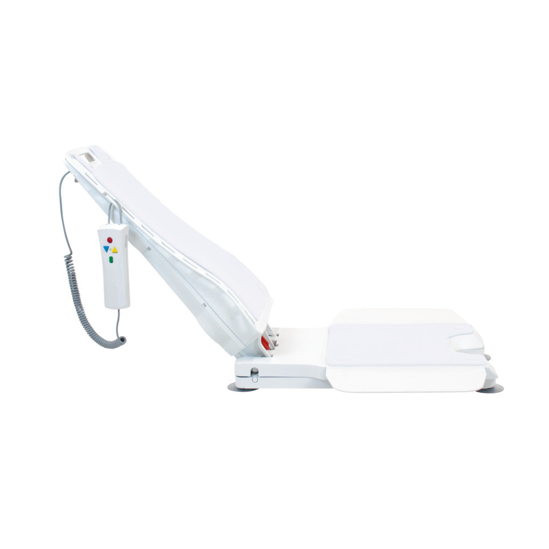 The Drive Bellavita Dive Bath Lift, shown partially upright, features an electric reclining backrest and seat, dual-column stability, and a wired remote with colored buttons. The product is white and set against a plain white background.
