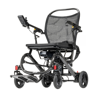 The Drive CarbonTouch Power Wheelchair is a lightweight model featuring a sleek black design, mesh backrest, small front and rear wheels, convenient footrests, and an intuitive hand control panel on the armrest.