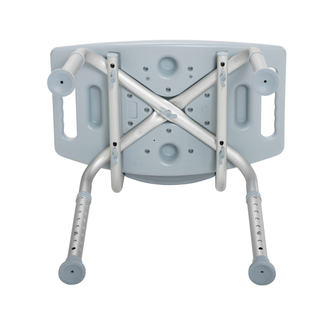 The Drive Deluxe Aluminum Bath Chair is shown upside down, featuring a light grey plastic seat with side handles, drainage holes, and four height-adjustable aluminum legs with rubber tips.