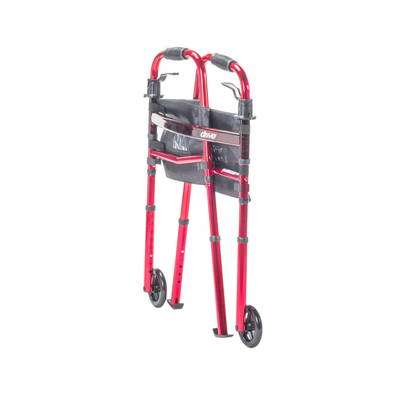 The Drive Deluxe Folding Travel Walker with 5" Wheels is red, features two front wheels, black hand grips, a black storage pouch on the frame, and is shown folded against a white background.