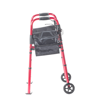 The Drive Deluxe Folding Travel Walker with 5" Wheels is a red, compact walker with black handles, two front wheels, and a black storage pouch, shown upright on a white background.