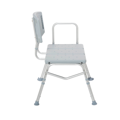 A side view of the Drive Bariatric Transfer Bench, a light gray adjustable shower bench with backrest, armrest, and rubber-tipped legs for stability, designed for heavy-duty bathroom safety and support.
