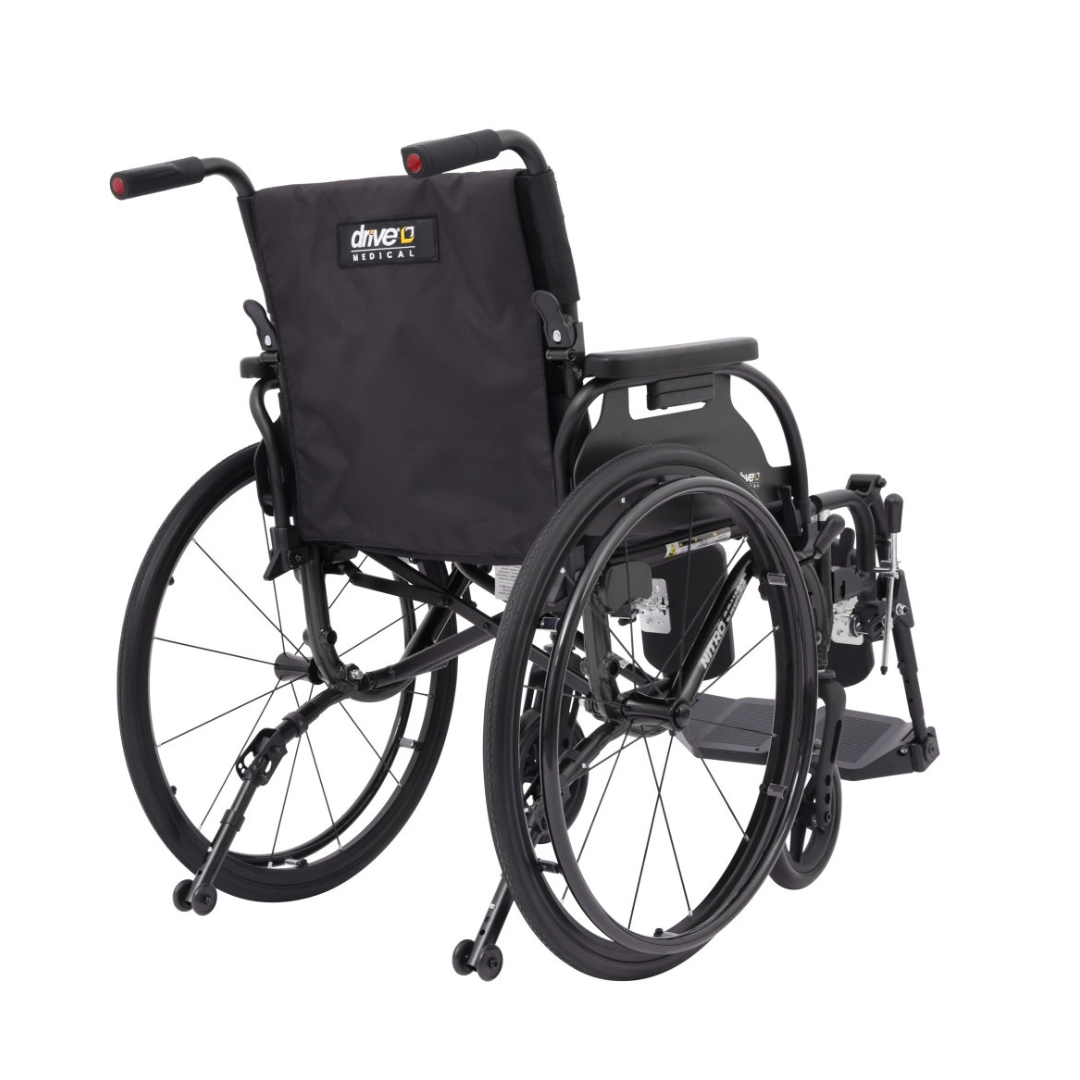 A black Drive Nitro Cruise Wheelchairs | Ultralight & Portable is shown from the rear, featuring large rear wheels, small front wheels, and a black fabric backrest. This ultralight aluminum wheelchair weighs just 28 lbs.