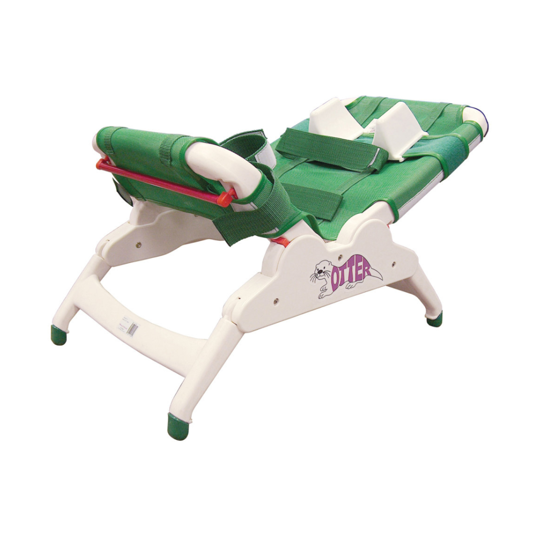 A green and white Drive Otter Bathing System waterproof reclining chair features an adjustable mesh backrest and seat, white frame, and safety straps for secure bathing. "Otter" name and otter graphic appear on the side.